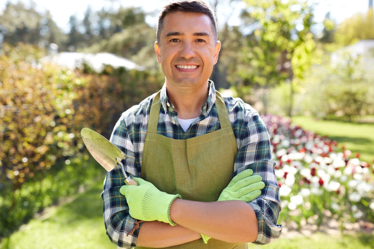 Gardener tending a garden by the house